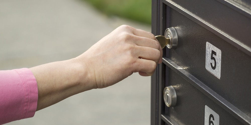 Unlocking a mailbox lock with a key.